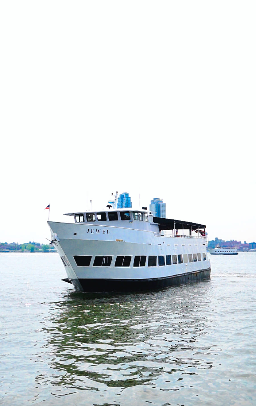 Jewel, a Harbor Social party yacht, underway on the Hudson River with the New York skyline behind it